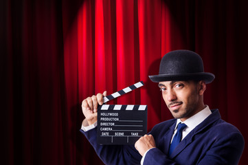 Man with movie clapper on curtain background