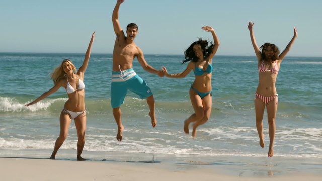 Happy friends jumping on the beach