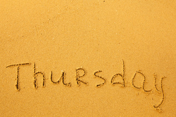 Thursday - written in sand on beach texture.