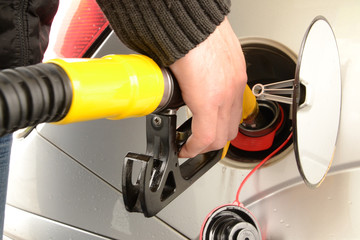 Menschliche Hand beim Tanken das Auto. Steigende Preise auf Diesel und Benzin.