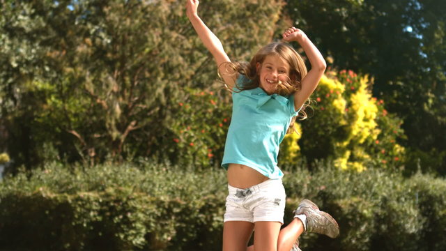 Cute little girl jumping in her garden