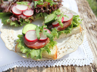 sandwich with sausage, radish, lettuce