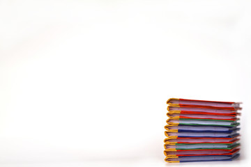 Stack of colorful books on white background, partial view.