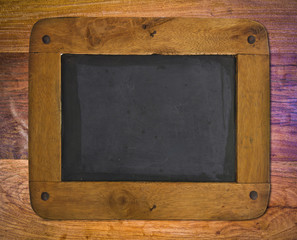 Obraz premium Old blackboard with a wooden frame on wood wall.