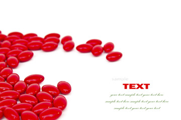 Red medicinal pills on a white background with space for text