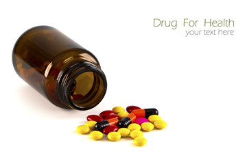 Pills, Tablets and Capsules spilled from a bottle on white backg