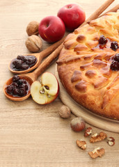 tasty homemade pie with jam and apples, on wooden table