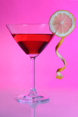 Red cocktail in martini glass  on pink background