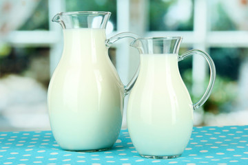 Pitchers of milk on table in room
