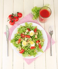 Caesar salad on white plate, on color wooden background