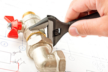 Men hands with spanner bind a faucet