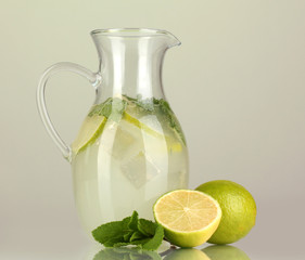 Lemonade in pitcher on green background