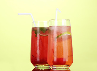 Two cherry cocktails with ice on green background