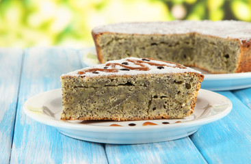 Delicious poppy seed cake on table on bright background