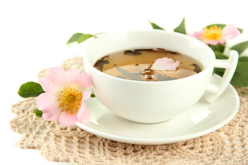 Cup of herbal tea with hip rose flowers, isolated on white