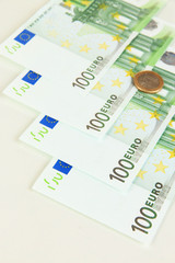 Euro banknotes and euro cents isolated on white