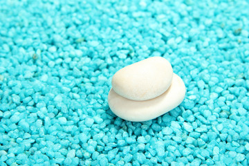 White stones on blue crystals of sea salt background