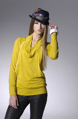 young woman in casual yellow clothes in hat posing