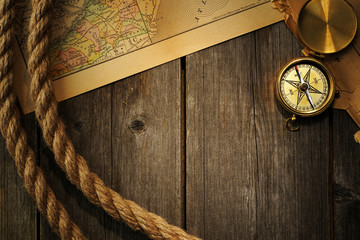 Antique compass and rope over old map