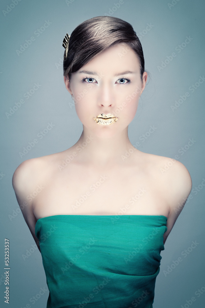 Wall mural Green portrait of a young woman with golden lips