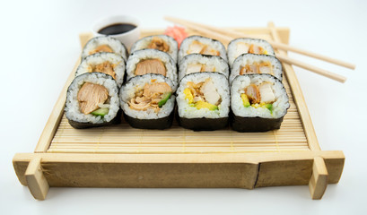 Teriyaki and fried chicken sushi rolls on Japanese bamboo mat