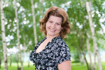 Fototapeta premium A woman in a birch grove in summer