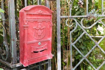 Traditional old English red postbox hang on gate