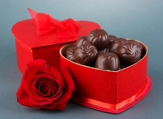 Chocolate candies in gift box, on grey background