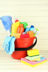 Cleaning items in bucket on  white wooden background