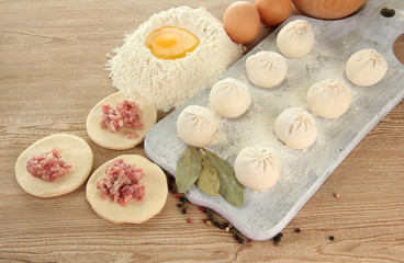 Fototapeta na wymiar Raw dumplings, ingredients and dough, on wooden table