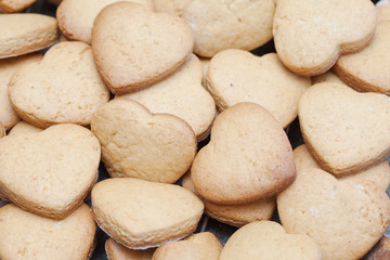 Fototapeta na wymiar Lots of freshly baked heart shaped biscuits