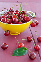 Fresh cherries in a yellow sieve