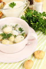 Tender young potatoes with sour cream and herbs in pan