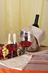 Vine and glasses on round table on cloth background