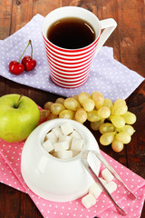Refined sugar in white sugar bowl on wooden background