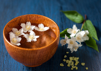 Spa. White flowers in a bowl of water on a vintage board