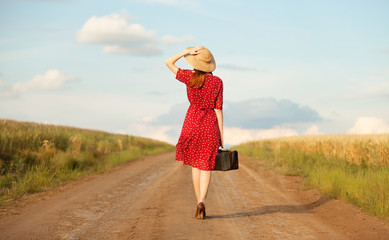 Redhead girl with suitcase at outdoor.
