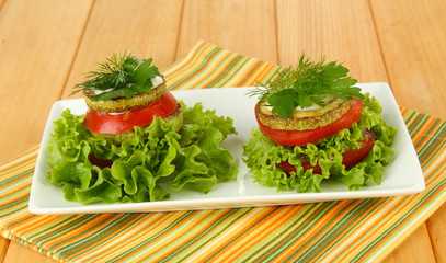 Tasty roasted marrow and tomato slices with salad leaves,