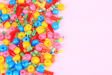 Different colorful beads on beige background