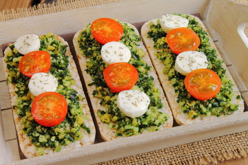 Rice cakes with pesto, cherry tomatoes and mozzarella