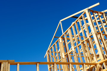 Wooden house frame against blue sky