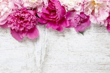 Obraz na płótnie Canvas Oszałamiająca różowe piwonie na białym rustykalnym tle drewnianych. Copy sp