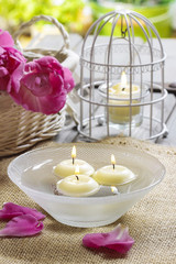 Floating candles in water, aromatic petals in the background