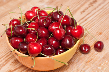 ripe cherries in a yellow bowl