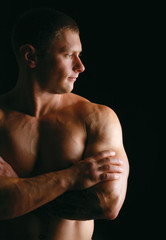 Fototapeta premium Healthy muscular young man. Isolated on black background