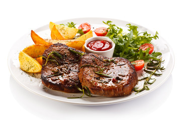 Grilled steaks, baked potatoes and vegetables