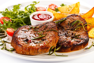 Grilled steaks, baked potatoes and vegetables