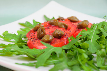 Salad with fresh tomatoes, capers and arugula