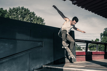 Skateboarder jumping stairs in the street.