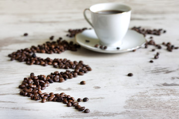 Cup of coffee with beans on retro vintage white planks concept
